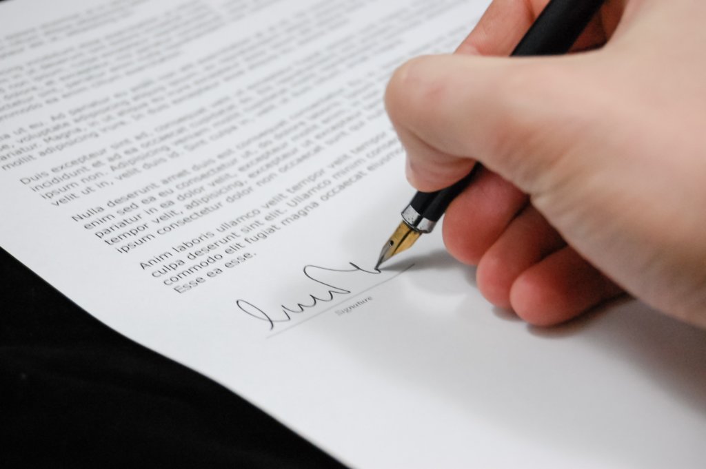 Photo of a person signing a document