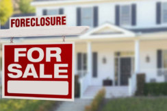 Foreclosure and For Sale sign infront of a home