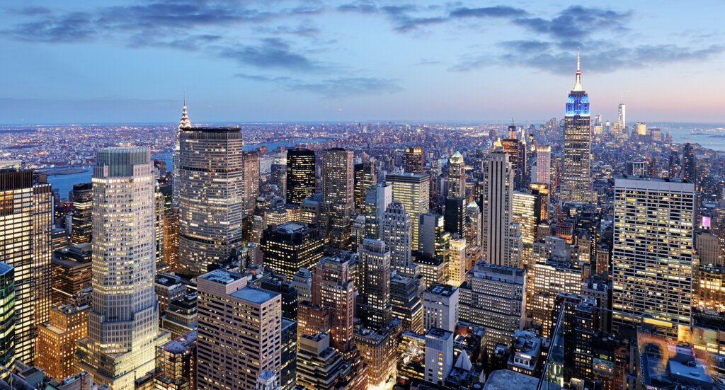 Aerial View of New York City, during a cool blue sunset and illuminated buildings.