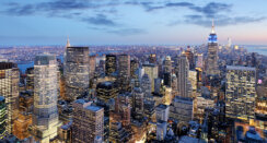 Aerial View of New York City, during a cool blue sunset and illuminated buildings.