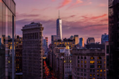 Rooftop view from Midtown, New York City, looking downtown towards Flatiron building and One World Trade Center during sunset.