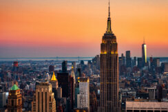 Aerial view of the skyline in New York City, with a beautiful sunset sky and views of Empire State Building and the Upper Bay.
